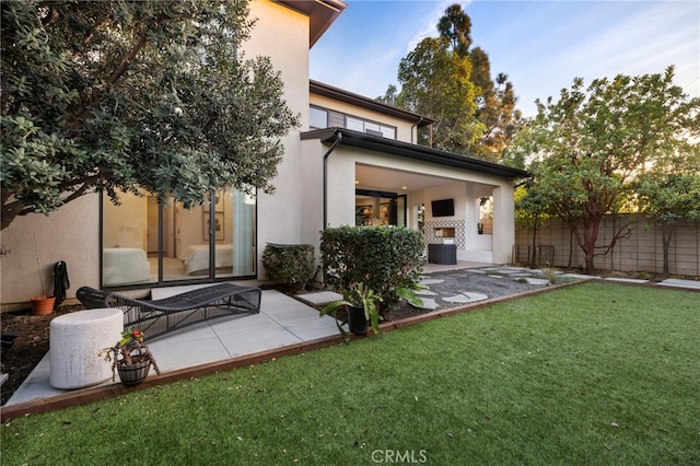 rear view of house with a lawn and a patio area