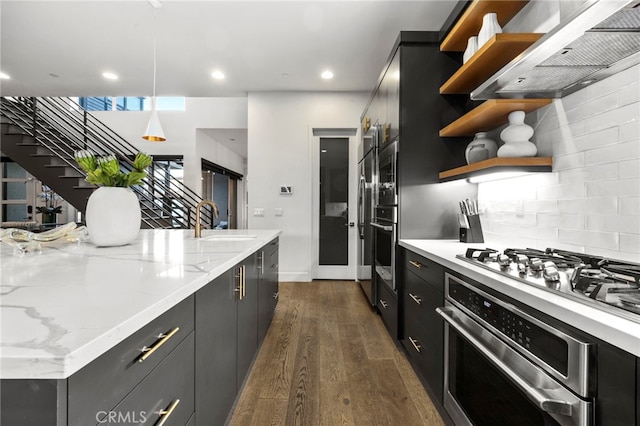 kitchen with pendant lighting, range hood, sink, oven, and gas stovetop