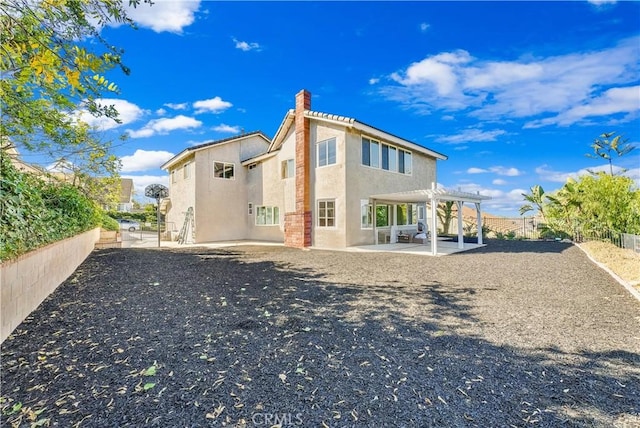 back of property with a pergola and a patio