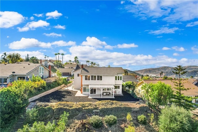 rear view of house featuring a mountain view and a patio