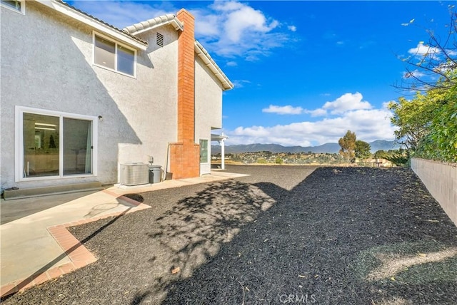 view of yard with central AC, a mountain view, and a patio