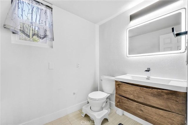 bathroom with toilet, vanity, and tile patterned flooring