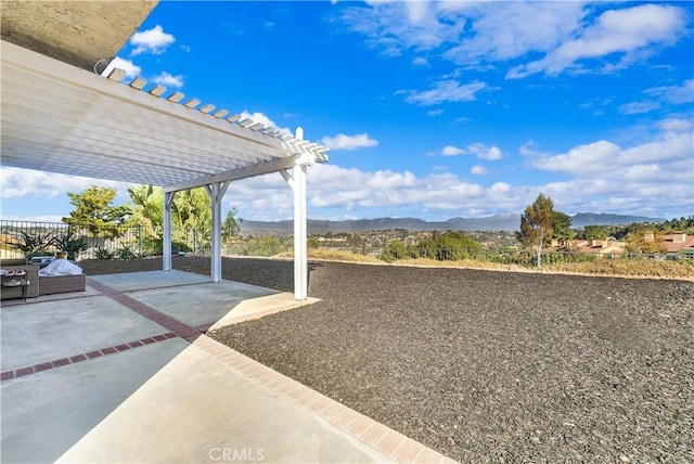 view of yard featuring a pergola, a patio area, and a mountain view