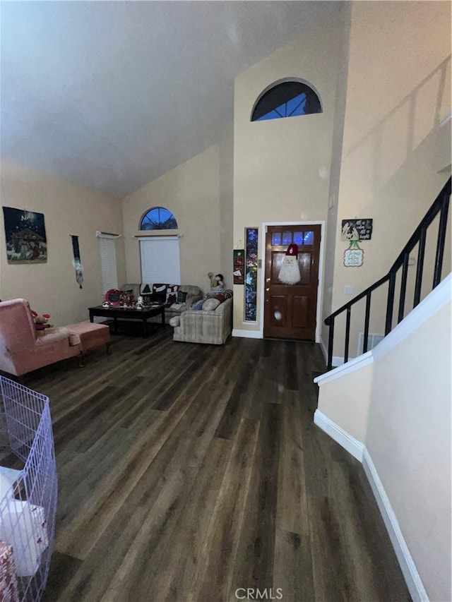 foyer entrance featuring dark wood-type flooring and high vaulted ceiling