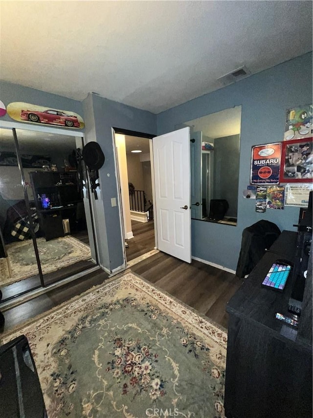 office space with baseboards, visible vents, and wood finished floors