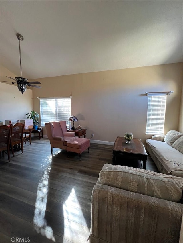 living area featuring baseboards, a ceiling fan, vaulted ceiling, and wood finished floors