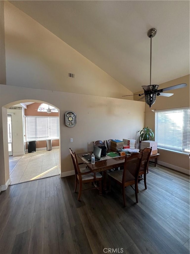 dining space with a wealth of natural light, visible vents, arched walkways, and wood finished floors