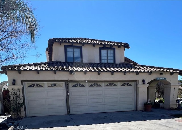 view of front facade with a garage, concrete driveway, and stucco siding