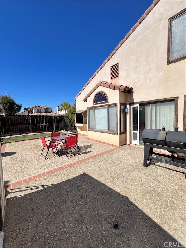 view of patio / terrace featuring outdoor dining area, fence, and a grill