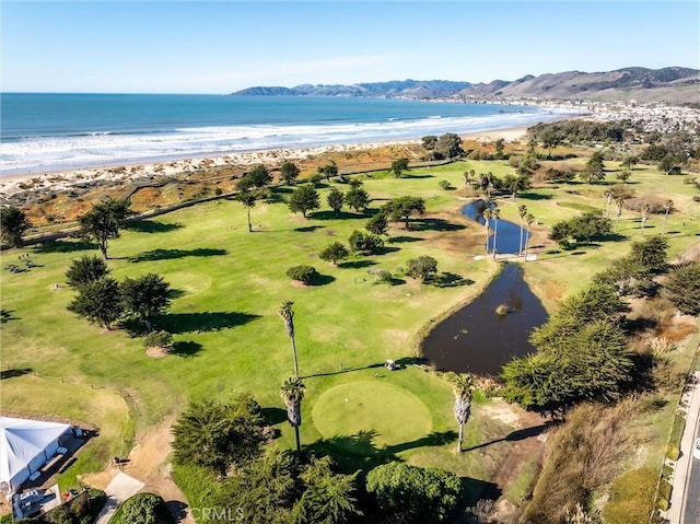 drone / aerial view with a water and mountain view and a beach view