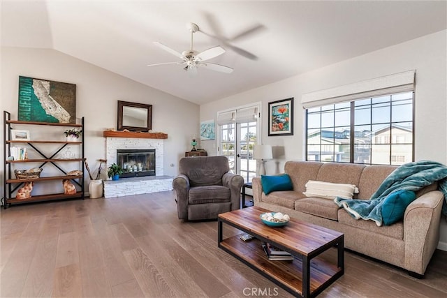 living room with ceiling fan, wood-type flooring, and vaulted ceiling