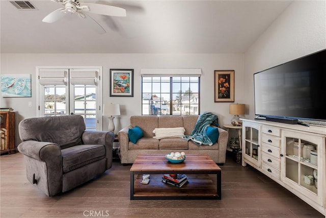 living room featuring ceiling fan, a wealth of natural light, and dark hardwood / wood-style flooring