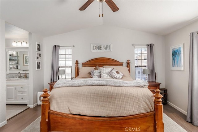 bedroom with lofted ceiling, connected bathroom, sink, ceiling fan, and light hardwood / wood-style flooring