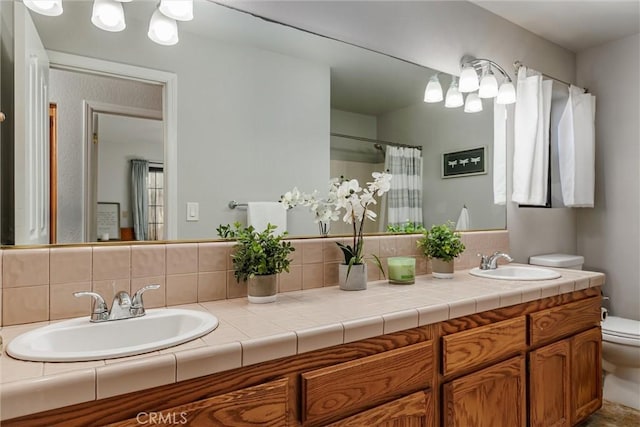 bathroom with vanity, toilet, and decorative backsplash