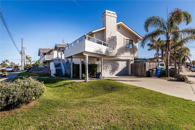 exterior space featuring a balcony, a yard, and a garage