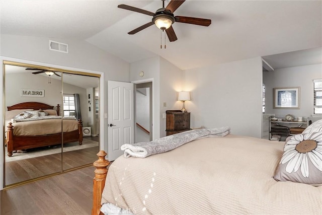 bedroom with ceiling fan, wood-type flooring, a closet, and vaulted ceiling