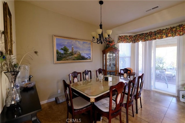 tiled dining room with a notable chandelier