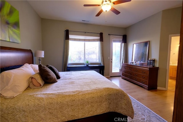 bedroom featuring ceiling fan, ensuite bathroom, light hardwood / wood-style flooring, and access to outside