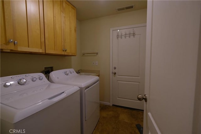 washroom featuring cabinets, sink, and independent washer and dryer