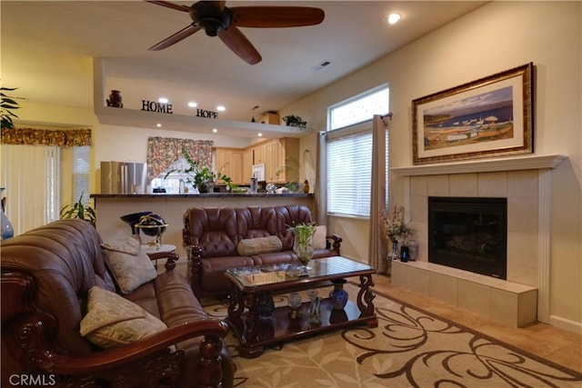 living room with ceiling fan and a fireplace