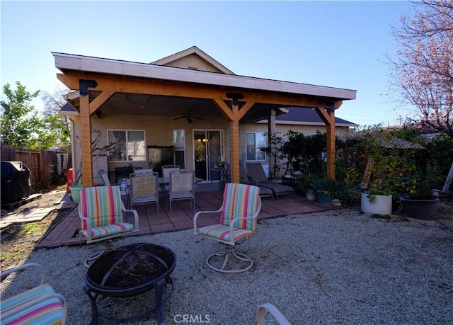 rear view of property featuring a fire pit, a patio, and ceiling fan