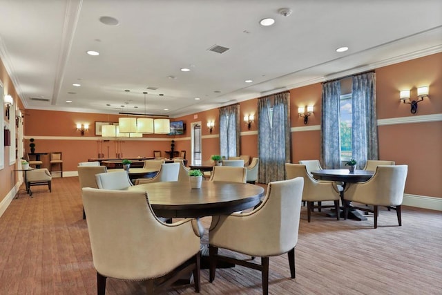 dining room with crown molding and light hardwood / wood-style floors