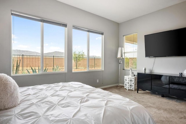 bedroom with light colored carpet and a mountain view