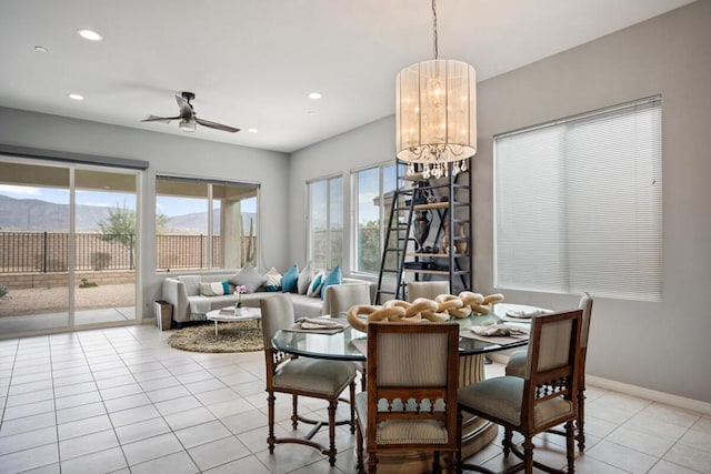 dining area featuring a mountain view, light tile patterned floors, and ceiling fan with notable chandelier