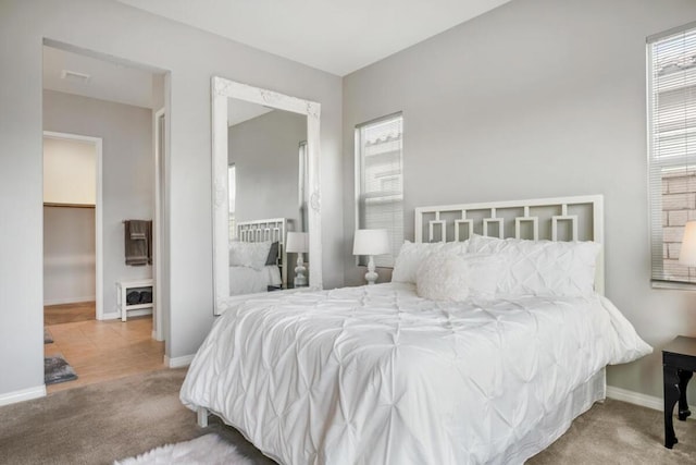 carpeted bedroom featuring a walk in closet