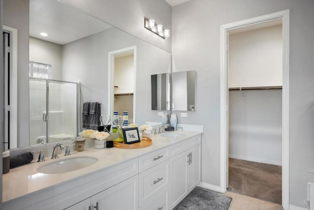 bathroom with a shower with shower door, tile patterned floors, and vanity