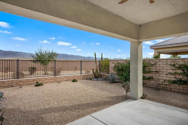 view of patio / terrace featuring a mountain view and ceiling fan