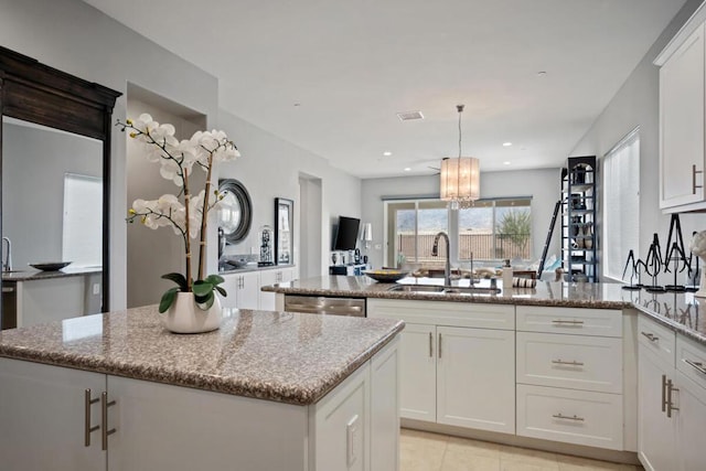 kitchen featuring white cabinets, dishwasher, and a center island with sink