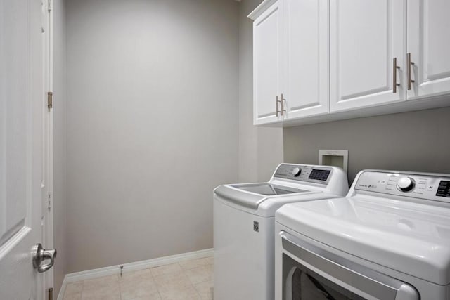 clothes washing area with cabinets and washing machine and dryer