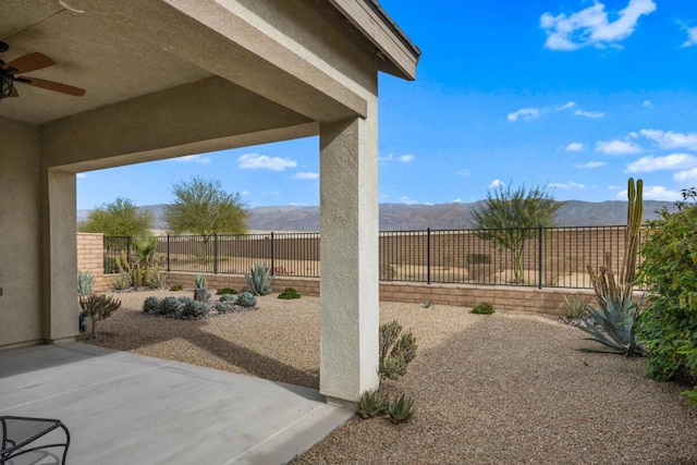 view of patio / terrace featuring ceiling fan and a mountain view