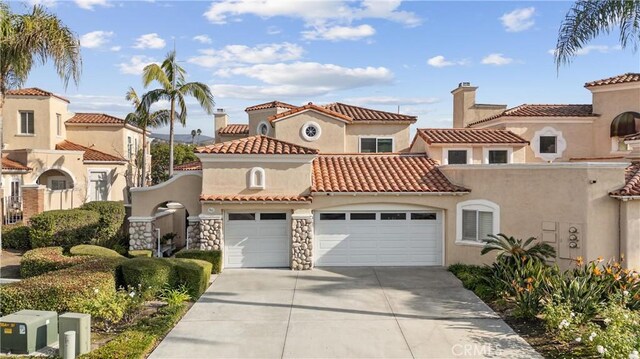 mediterranean / spanish-style house with a garage