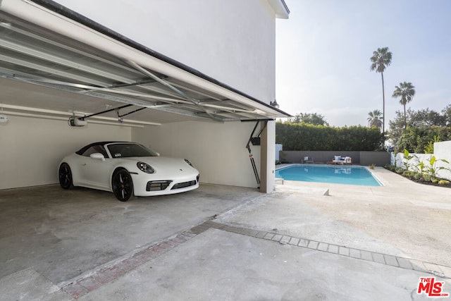 garage featuring a garage door opener and a fenced in pool