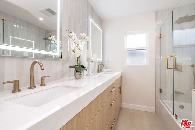 bathroom with combined bath / shower with glass door, vanity, and tile patterned flooring