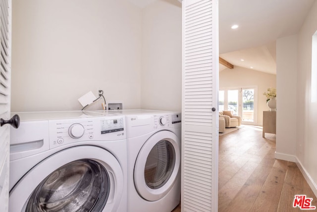 laundry room featuring washer and dryer and light hardwood / wood-style floors