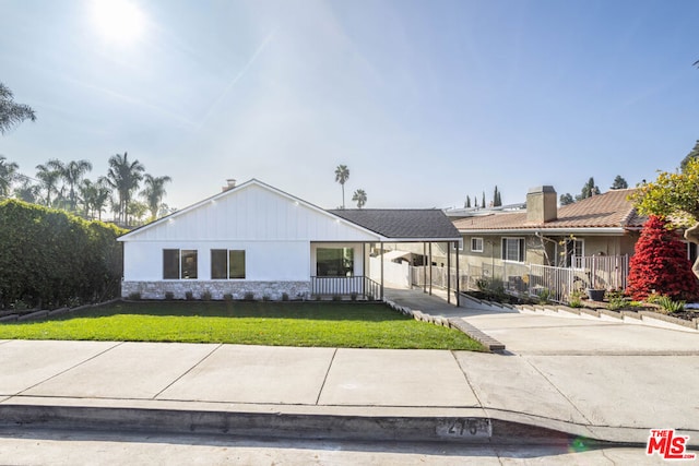 view of front of house with a carport and a front yard