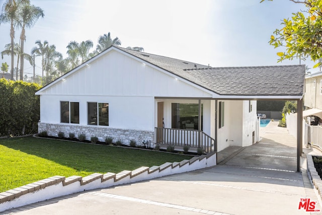 view of front of house with a front yard, covered porch, and a carport