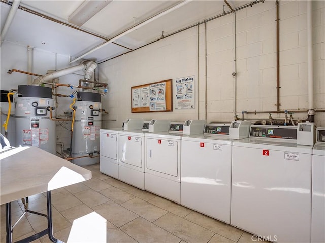 washroom featuring light tile patterned flooring, washing machine and clothes dryer, and gas water heater