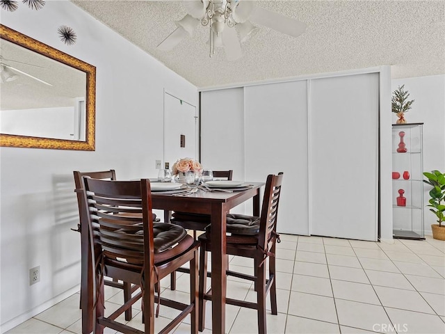 tiled dining space featuring a textured ceiling and ceiling fan