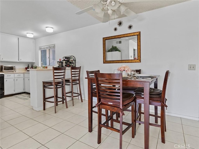 tiled dining space with ceiling fan