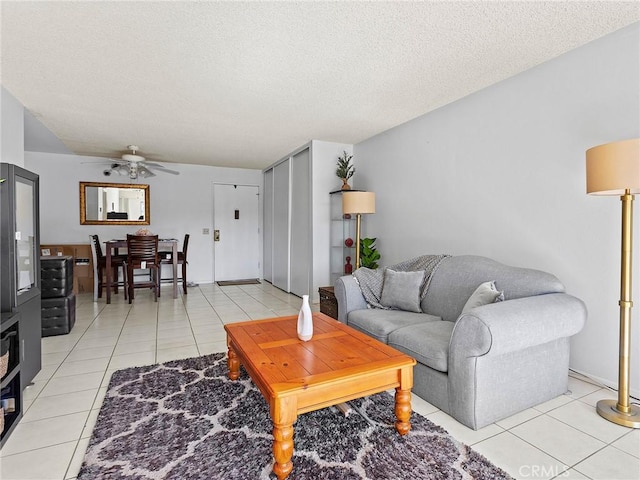 tiled living room with a textured ceiling and ceiling fan