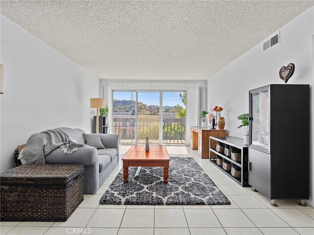 living room with a textured ceiling and light tile patterned floors