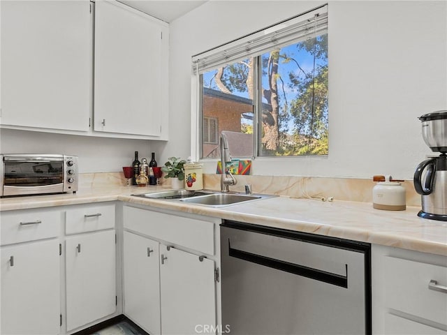 kitchen with white cabinets, dishwasher, and sink