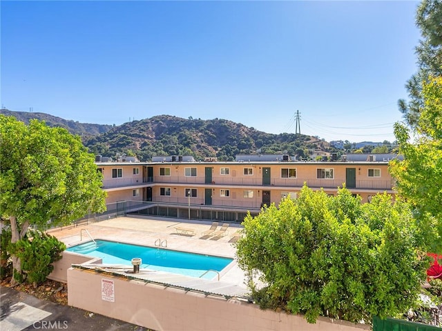 view of swimming pool with a mountain view and a patio area