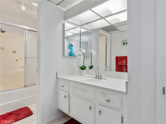 bathroom featuring combined bath / shower with glass door, vanity, and tile patterned flooring