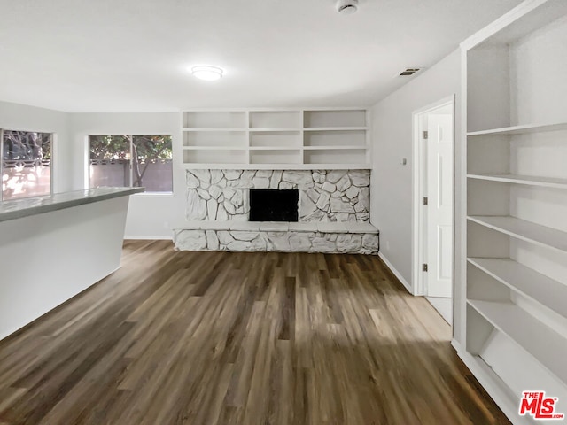 unfurnished living room featuring dark hardwood / wood-style floors and a fireplace