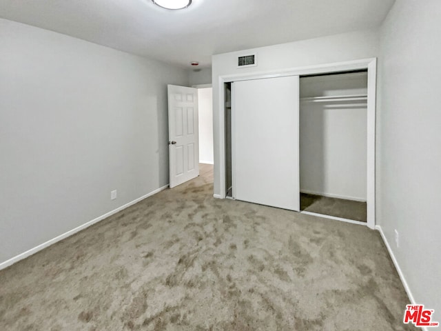 unfurnished bedroom with carpet floors and a closet